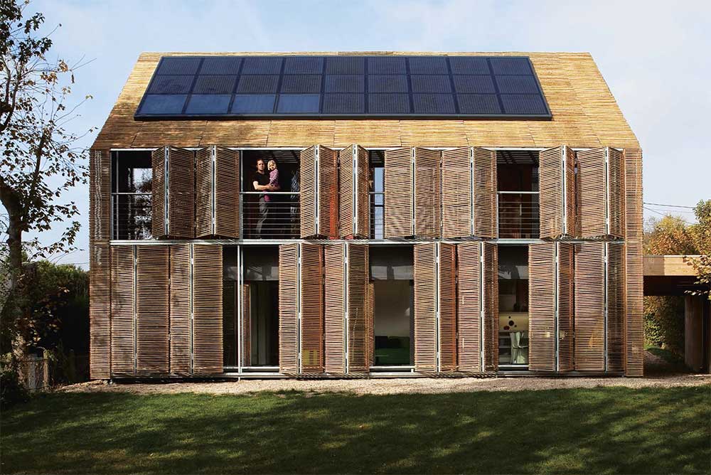 A passive house in Bessancourt, France, which features untreated bamboo cladding - including within adjustable shutters which can shade or open up the house as necessary.