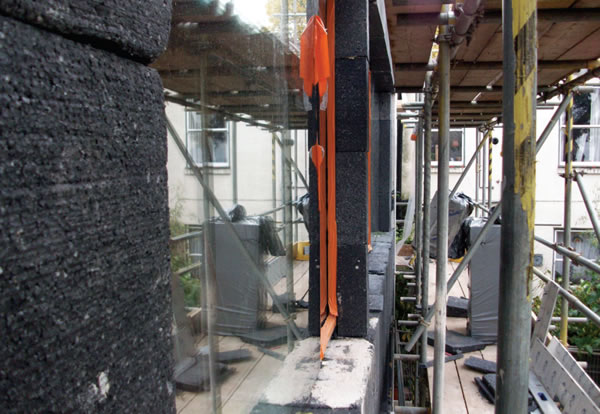 Enersign triple-glazed window being installed in the new clay block wall, with external insulation fitted to the window frame