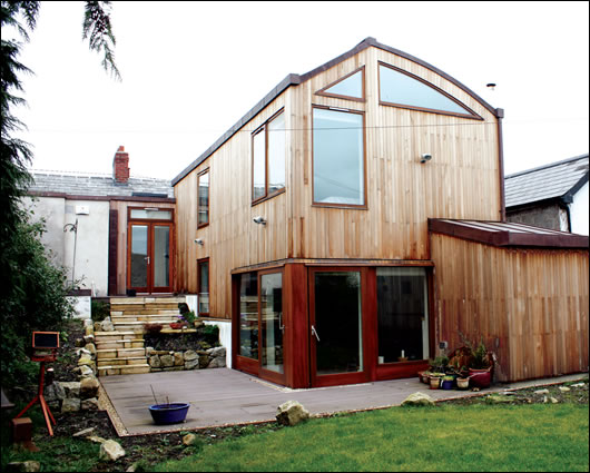 The walls are timber-clad to the south and lime-rendered to the street-facing north